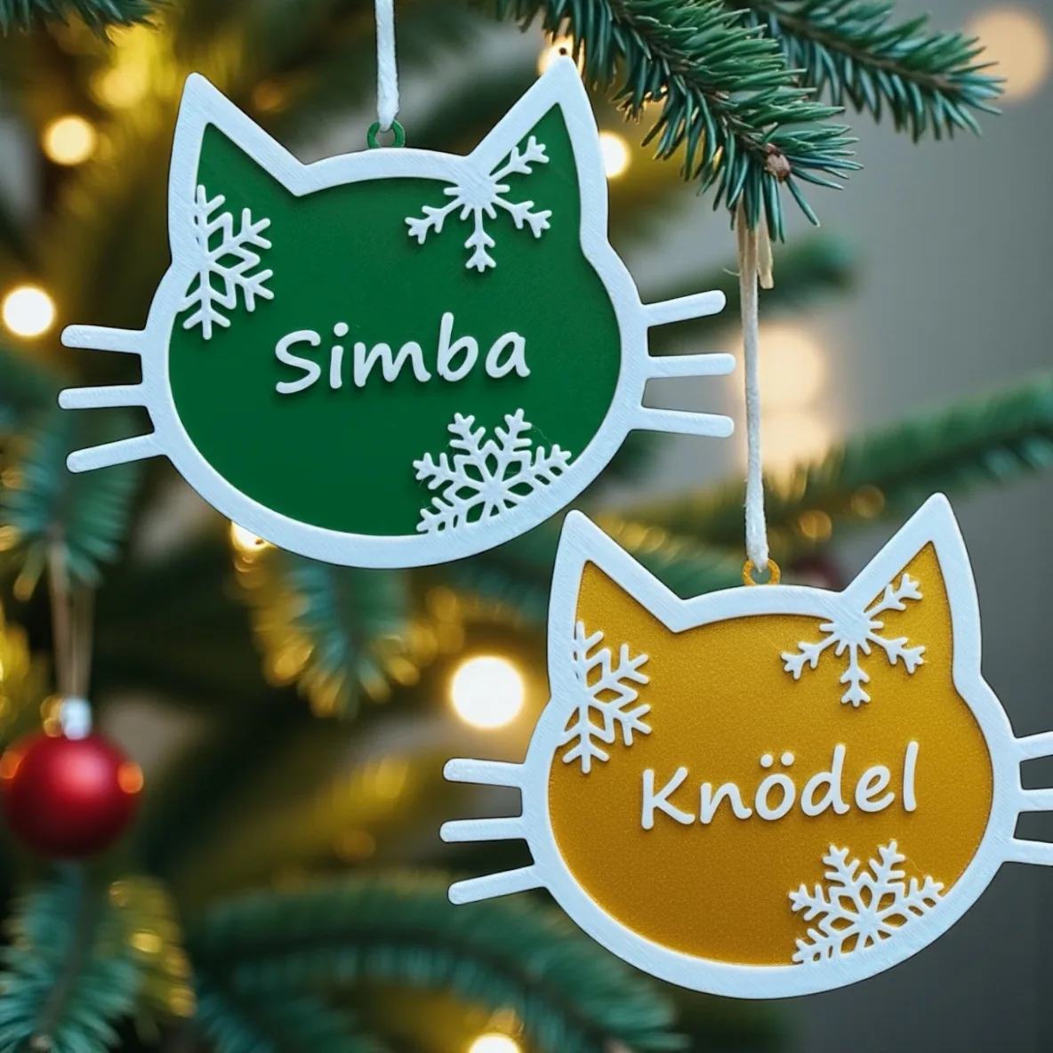 Zwei personalisierte 3D gedruckte Christbaumanhänger in Katzen-Form mit Namen Simba (grün) und Knödel (gelb) — Weihnachts-Deko aus Wien, sofortdruck.at